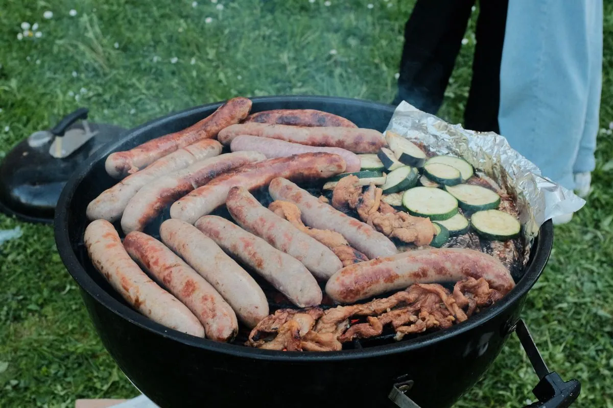Food truck barbecue avec fumee sortant du smoker, viande grillee au premier plan